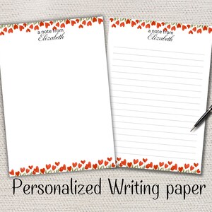 Peut inclure: Deux feuilles de papier à lettres blanc personnalisé. Les bords supérieur et inférieur sont décorés de fleurs rouges en forme de cœur et de feuilles vertes. Le texte "a note from Elizabeth" est imprimé en haut. Le bas de l'image indique "Personalized Writing paper".