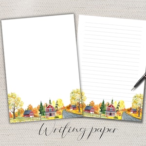 Op de afbeelding: Twee vellen wit schrijfpapier met een aquarel illustratie van een landelijke herfstscène. De scène toont rode huizen, bomen met gele bladeren en een kronkelende weg. Een zwarte pen ligt op het gelijnde vel. De woorden "Writing paper" staan onderaan.