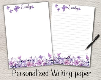 Puede incluir: Dos hojas de papel de escritura personalizadas con un diseño floral y de mariposas en tonos morados y rosas. El nombre "Emily" está escrito en la parte superior. Una hoja está rayada y la otra en blanco. Las palabras "Personalized Writing paper" están en la parte inferior.