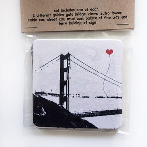 May include: A set of 8 reusable paper coasters featuring black and white illustrations of the Golden Gate Bridge, a red heart balloon, and the text "sf lover's assorted set of 8 reusable paper coasters". The set includes one of each: 2 different golden gate bridge views, sutro tower, cable car, street car, muni bus, palace of fine arts and ferry building sf sign.