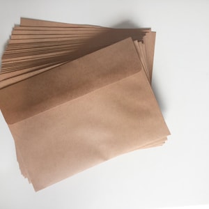 May include: A stack of brown paper envelopes. The top envelope is folded over to reveal the inside.
