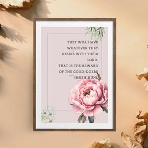 Op de afbeelding: Een ingelijste print met een citaat in zwarte tekst op een lichtroze achtergrond. Onderaan staat een grote roze pioenroos met groene bladaccenten. Het citaat luidt: "ZIJ ZULLEN HEBBEN WAT ZIJ WENSEN VAN HUN HEER. DAT IS DE BELONING VAN DE GOEDEN (MUSHINUN)."