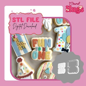 May include: A collection of decorated cookies featuring a giraffe, a number one with balloons, a party hat, and a bear, alongside a central cookie reading FUN TO BE ONE. A clear plastic cookie cutter for the text is shown on the right side.