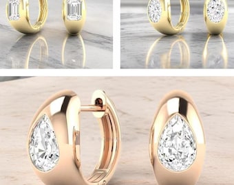 May include: Gold hoop earrings with a pear-shaped diamond. The earrings have a polished finish and a secure clasp. The diamonds sparkle, reflecting light. The earrings are a classic jewelry piece.