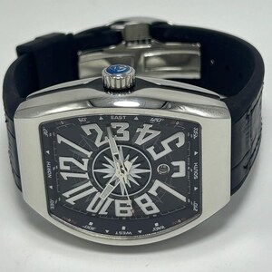 May include: A silver wristwatch with a black face, large white numerals, and a compass design. The watch has a black rubber strap and a silver bezel. The watch face displays the words "EAST", "SOUTH", "WEST", and "NORTH".