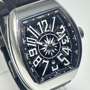 May include: A silver wristwatch with a black face, large white numerals, and a compass rose design. The watch has a black leather strap. The words "SWISS MADE" are visible.