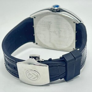 May include: A luxury wristwatch with a silver rectangular case and a dark blue leather strap. The watch has a silver clasp with a logo and a blue crown. The watch's back is silver with etched details.