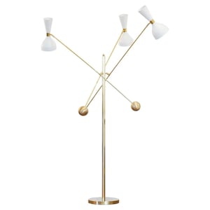 Könnte beinhalten: Eine moderne Stehlampe aus der Mitte des Jahrhunderts mit einem goldfarbenen Metallrahmen und vier weißen, konisch geformten Schirmen. Die Lampe hat einen runden Sockel und kugelförmige Akzente. Die Schirme sind in verschiedene Richtungen abgewinkelt.