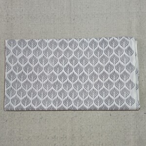 May include: A rectangular piece of fabric featuring a repeating pattern of grey stylized leaf shapes arranged in vertical columns against a white background. The design consists of symmetrical, pointed oval motifs with internal line details.