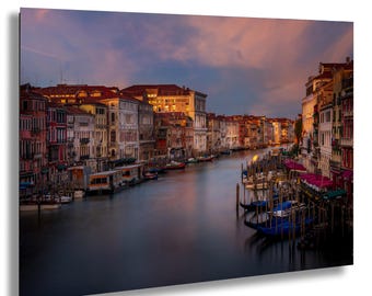 May include: A scenic canvas print of Venice, Italy, featuring the Grand Canal at sunset. The image showcases colorful buildings lining the canal, gondolas, and a vibrant sky with shades of pink and blue.