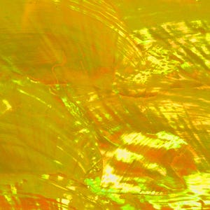 May include: Abstract background with a blend of yellow, orange, and green hues. The colors are layered and swirled, creating a textured, iridescent effect. The light reflects off the surface, producing a shimmering, glossy appearance. The overall effect is a vibrant, artistic design.