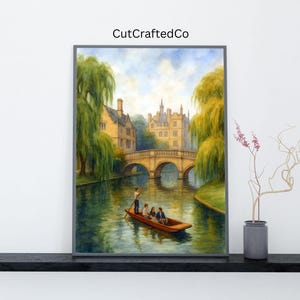 May include: A framed watercolor painting depicts a river scene with a bridge and buildings. A wooden boat with people floats on the water. The painting has a gray frame and the text "CutCraftedCo" in the upper right corner.
