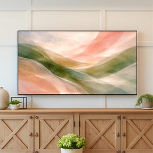 May include: Abstract landscape art print featuring flowing layers of color. The artwork showcases soft hues of green, peach, and beige, creating a serene and calming aesthetic. The piece is framed in a sleek black frame, suitable for home decor.