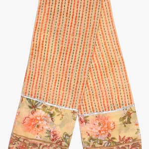 K&ouml;nnte beinhalten: Hellorangefarbener und cremefarbener Schal mit vertikalem Streifenmuster. Der Schal hat einen floralen Rand mit gro&szlig;en orangefarbenen Blumen und silberner Verzierung. Der Schal ist aus leichtem Stoff gefertigt.
