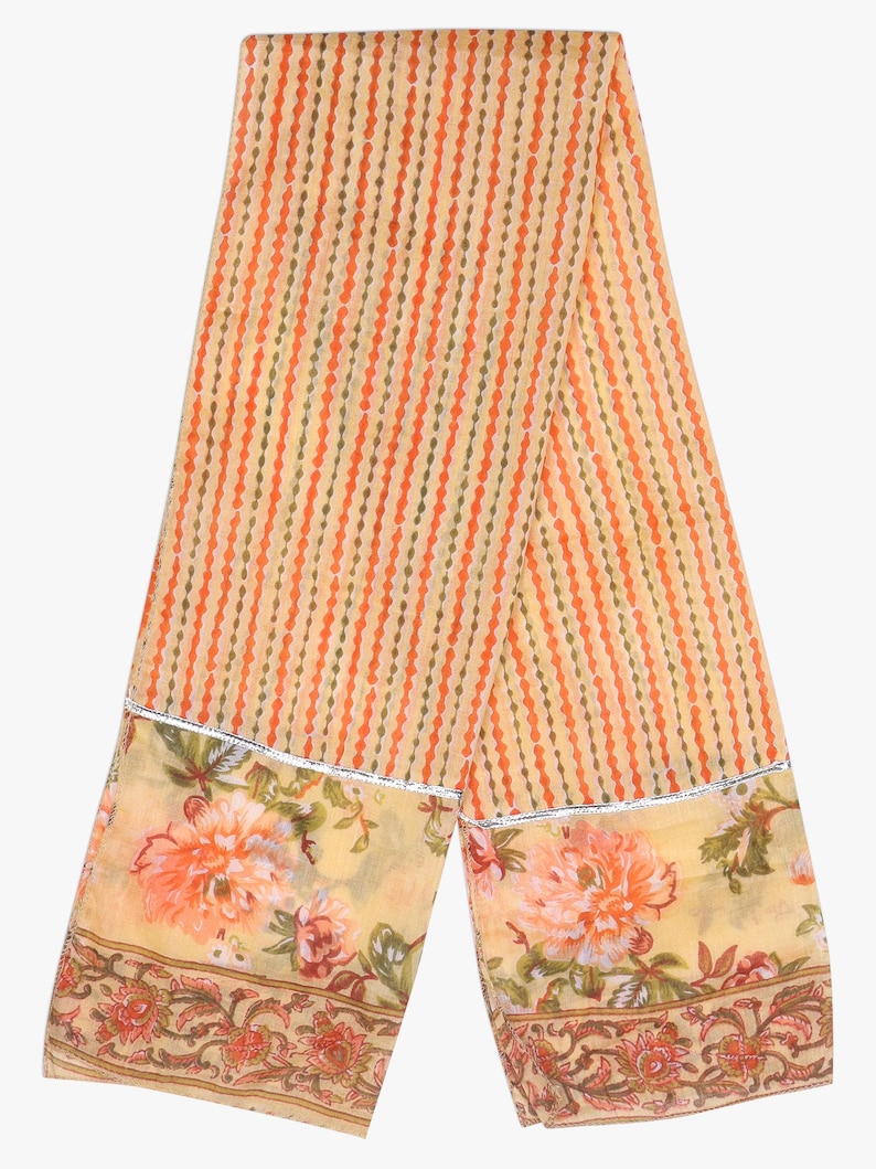 K&ouml;nnte beinhalten: Hellorangefarbener und cremefarbener Schal mit vertikalem Streifenmuster. Der Schal hat einen floralen Rand mit gro&szlig;en orangefarbenen Blumen und silberner Verzierung. Der Schal ist aus leichtem Stoff gefertigt.