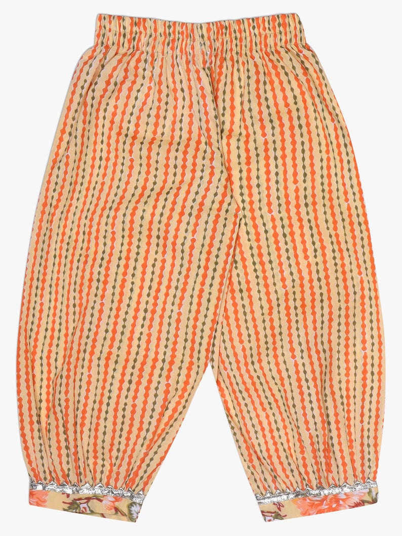 K&ouml;nnte beinhalten: Eine Hose mit orangefarbenem und gelbem Muster mit vertikalen Streifen. Die Hose hat einen gerafften Bund und Manschetten mit floralen und silbernen Verzierungen. Der Stoff hat ein gepunktetes Streifendesign in Orange und Olivgr&uuml;n.