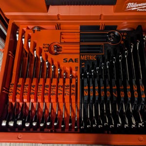 May include: An open orange toolbox with a set of black and silver wrenches. The wrenches are organized in a red tray, with SAE and Metric measurements. The toolbox is labeled "Milwaukee PACKOUT".