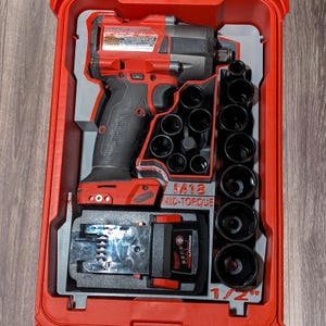 May include: A red and black M18 Mid-Torque impact wrench kit with a black socket set and a red battery pack, all neatly organized within a red case. The socket set includes various sizes, and the case is designed for tool storage and transport.