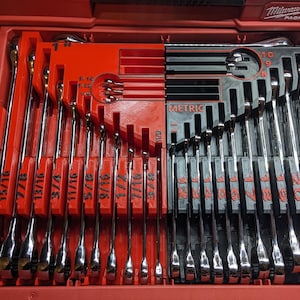 May include: A red toolbox with a set of wrenches. The wrenches are chrome and arranged in a red and black organizer. The wrenches are labeled with both fractional and metric measurements.