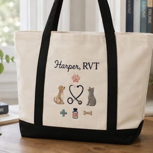 Peut inclure: Un sac fourre-tout en toile couleur crème avec des anses et une base noires. L'avant présente des broderies incluant un chien, un chat, un stéthoscope, une empreinte de patte, une croix médicale, un flacon de médicament, un os et le texte Harper, RVT.