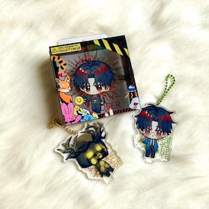 May include: A square cardboard box featuring a cartoon character with dark hair and red highlights, alongside two acrylic keychains. One keychain depicts a dark-haired character, the other a dark-haired figure with antlers. The box text reads Only suitable for Good Friend.