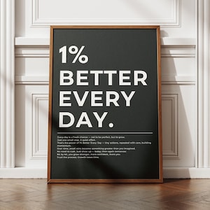 May include: A framed print with the text "1% BETTER EVERY DAY" in large white letters on a dark gray background. The print is in a brown wooden frame and is displayed against a white wall.