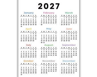 May include: A 2027 wall calendar printed on a white background. The year 2027 is displayed in large black text at the top. Each month is listed with its name in a unique color, followed by a grid of dates organized by days of the week.