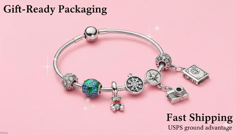 May include: A silver charm bracelet with various charms, including a globe, a camera, a book, a snowflake, and a teddy bear. The bracelet is on a pink background. The text "Gift-Ready Packaging" is at the top.