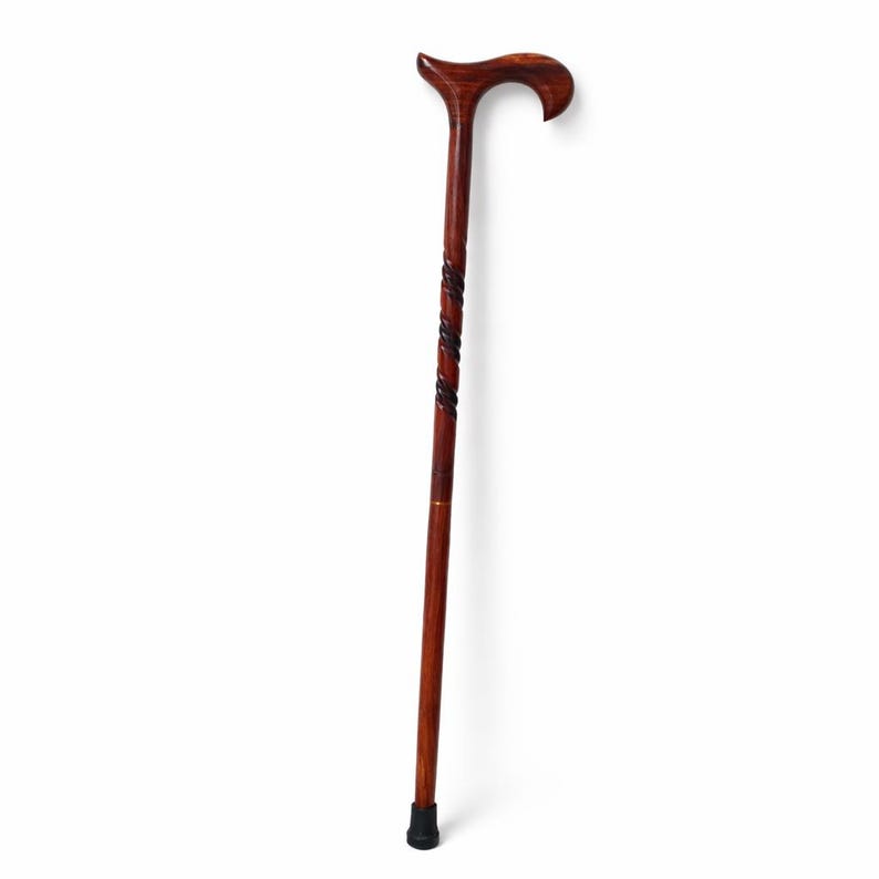 May include: A dark brown wooden cane with a curved handle. The cane features a decorative twisted design on the upper shaft and a black rubber tip. The cane is approximately 36 inches in length.