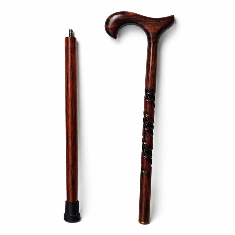 May include: A dark brown wooden cane with a curved handle and a decorative spiral design on the shaft. The cane is shown disassembled, with the handle and shaft separated. The shaft has a black rubber tip for stability.