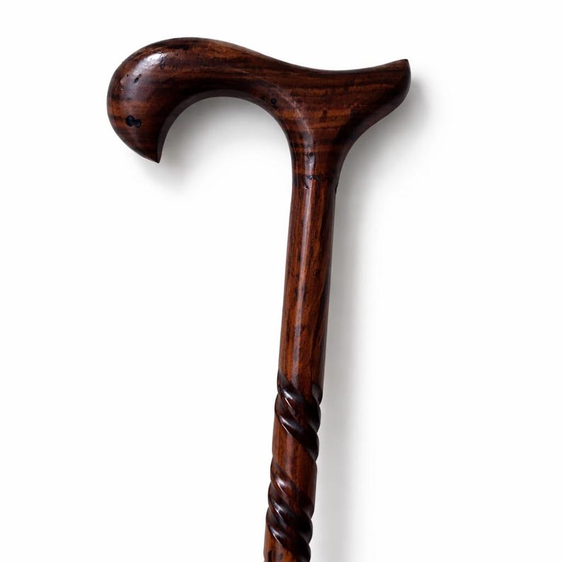 May include: A dark brown wooden cane with a curved handle and a spiral design on the lower portion. The cane is made of polished wood, showcasing the natural grain and texture. The handle is smooth and ergonomic.