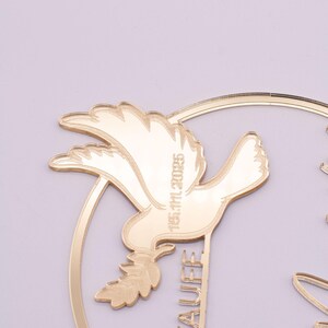 Detailansicht der Taube und des filigranen Eukalyptuskranzes aus goldfarbenem Spiegelacryl – dekorative Elemente des personalisierten Tortenaufsatzes.