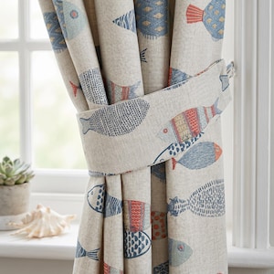 Puede incluir: Cortinas beige con un patrón repetido de peces estilizados en azul, rojo y amarillo. Las cortinas se sujetan con un recogedor a juego. El diseño es náutico y adecuado para una habitación con temática costera.