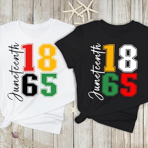 May include: Two t-shirts, one white and one black, each with the word "Juneteenth" in a vertical script. Below, the numbers "18" in yellow and white, and "65" in green and red, are displayed prominently. The shirts are on a light wood background.