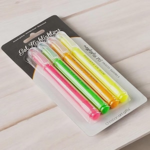 May include: A pack of four gel highlighters in pink, green, orange, and yellow. The highlighters are in a clear plastic package with the words "Gel Highlighters" and "Christian art gifts" printed on the packaging.