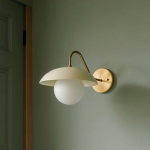Op de afbeelding: Een set van drie keramische mokken met een gespikkelde, matte afwerking. De mokken zijn in crème, lichtbruin en donkerbruin. Elke mok heeft een eenvoudig, minimalistisch ontwerp.