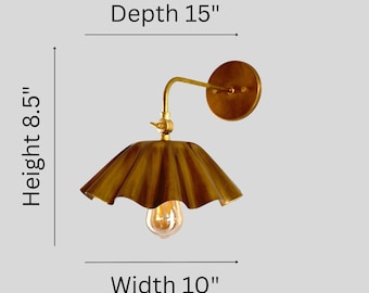 May include: A brass wall sconce with a scalloped shade and an exposed light bulb. The fixture features a circular wall mount and an angled arm. Dimensions are clearly labeled as 15 inches in depth, 8.5 inches in height, and 10 inches in width.