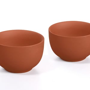 Peut inclure: Deux bols de couleur terre cuite de forme arrondie. Les bols sont faits d'un matériau mat et ont un design simple et minimaliste. Les bols conviennent pour servir des aliments ou comme objets décoratifs.