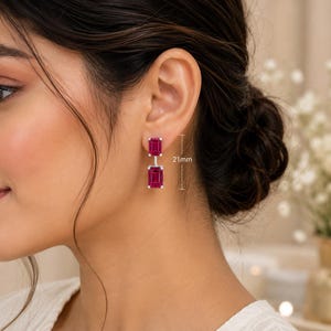 Pode incluir: Um brinco pendente com duas pedras retangulares de cor rosa profundo, lapida&ccedil;&atilde;o esmeralda, engastadas em metal prateado. O comprimento total do brinco &eacute; de 21mm, conforme indicado pelo gr&aacute;fico de medi&ccedil;&atilde;o ao lado da pe&ccedil;a de joalharia.