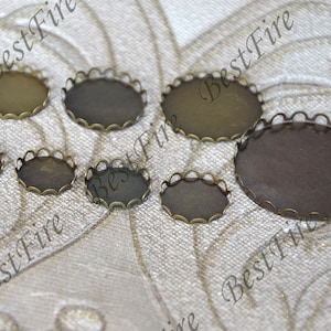 Puede incluir: Un conjunto de siete engastes de metal redondos y festoneados en varios tamaños. Los engastes son de color bronce antiguo y tienen un acabado liso y pulido.