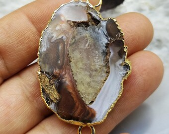 May include: A natural agate pendant with a gold-colored trim and two loops. The stone features a mix of brown, white, and beige tones. The text "1#" is visible on the bottom left.