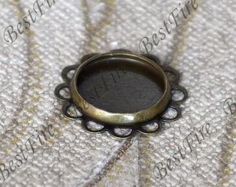 Puede incluir: Un colgante redondo de metal de color bronce con un borde festoneado y un inserto de vidrio transparente. El colgante está diseñado para su uso en la fabricación de joyas.