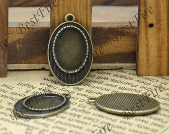 May include: Antique bronze oval pendant trays with a textured border and a loop for attaching to a chain. The trays are empty, ready to be filled with a custom design. Ideal for jewelry making.