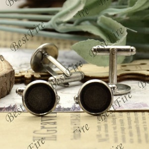 Può includere: Due gemelli d'argento con inserti rotondi neri. I gemelli hanno un design semplice e sono un accessorio classico.
