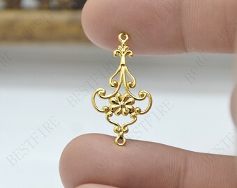 May include: Gold-toned metal pendant with a decorative floral design. The pendant has a loop at the top for attaching to a chain or cord.