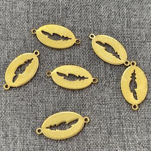 Puede incluir: Seis abalorios ovalados de metal de color dorado con un diseño de pluma recortada. Cada abalorio tiene dos pequeños agujeros para sujetarlo a joyas u otras manualidades.