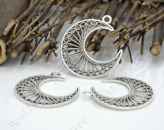 May include: Three silver filigree crescent moon charms with a decorative openwork design. The charms have a loop at the top for attaching to jewelry or other crafts.