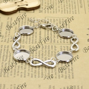 May include: Silver infinity charm bracelet with four round glass cabochon settings. The bracelet has a lobster claw clasp.