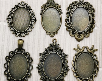 May include: Six antique gold-toned metal pendant frames with oval glass inserts. The frames have different decorative designs, including floral, leaf, and bird motifs. The frames are numbered 1 through 6.