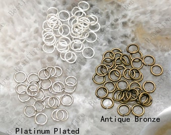 Puede incluir: Un surtido de pequeños anillos abiertos en tres acabados: plateado, platino y bronce antiguo. El texto "Silver Plated", "Platinum Plated" y "Antique Bronze" es visible.